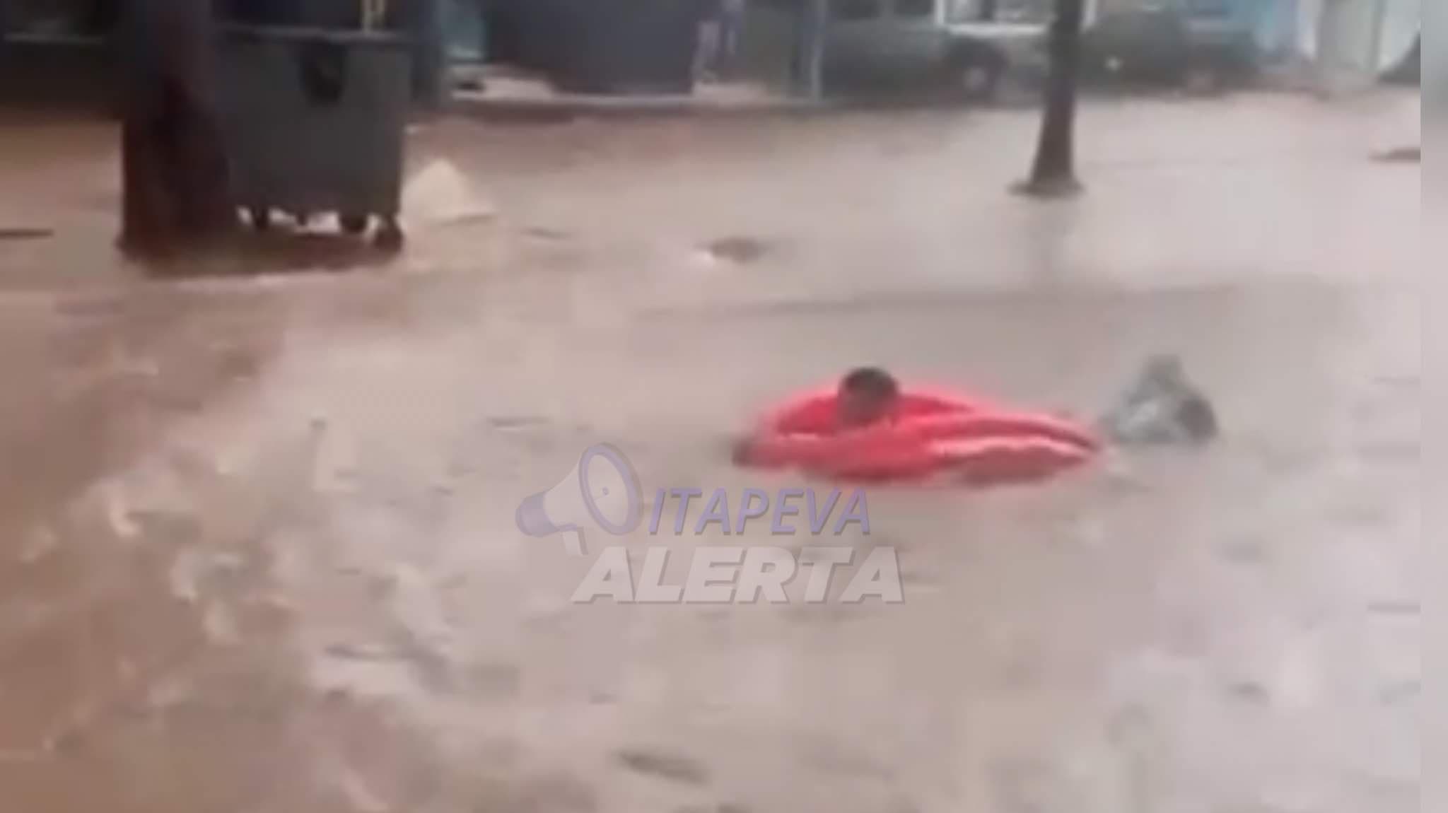 Cena inusitada durante temporal, com uma piscina inflável, homem se joga em enxurrada